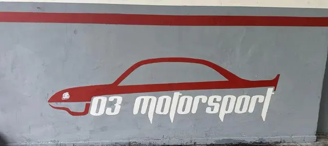 Il logo 03motorsport sul muro dell'officina