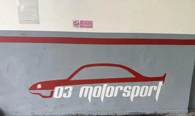 Il logo 03motorsport dipinto sul muro dell'officina